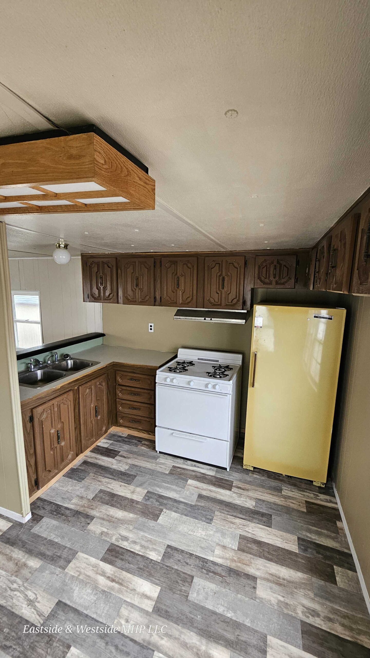 2-bedroom, 1-bathroom home for sale in Eastside Mobile Home Park with bright living spaces and a charming woody-like interior.