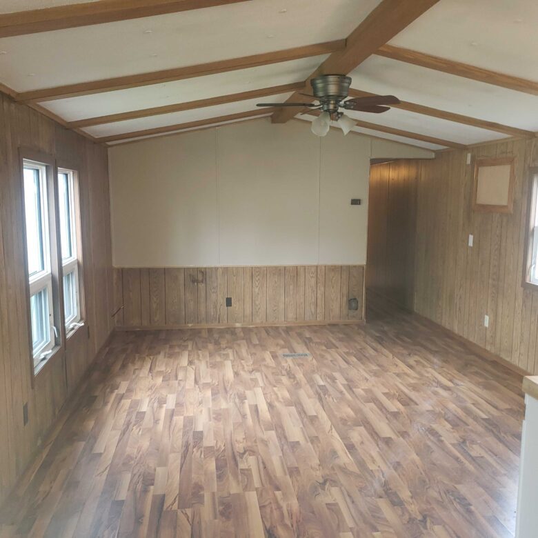2-bedroom, 1-bathroom home for sale or rent-to-own in Carman Terrace Mobile Home Park with bright living spaces and a woody-like interior.