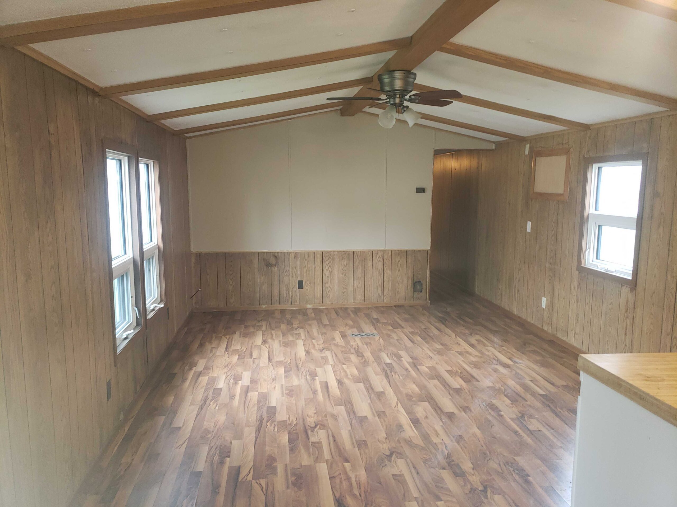 2-bedroom, 1-bathroom home for sale or rent-to-own in Carman Terrace Mobile Home Park with bright living spaces and a woody-like interior.