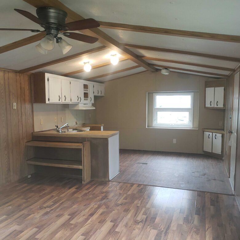 2-bedroom, 1-bathroom home for sale or rent-to-own in Carman Terrace Mobile Home Park with bright living spaces and a woody-like interior.