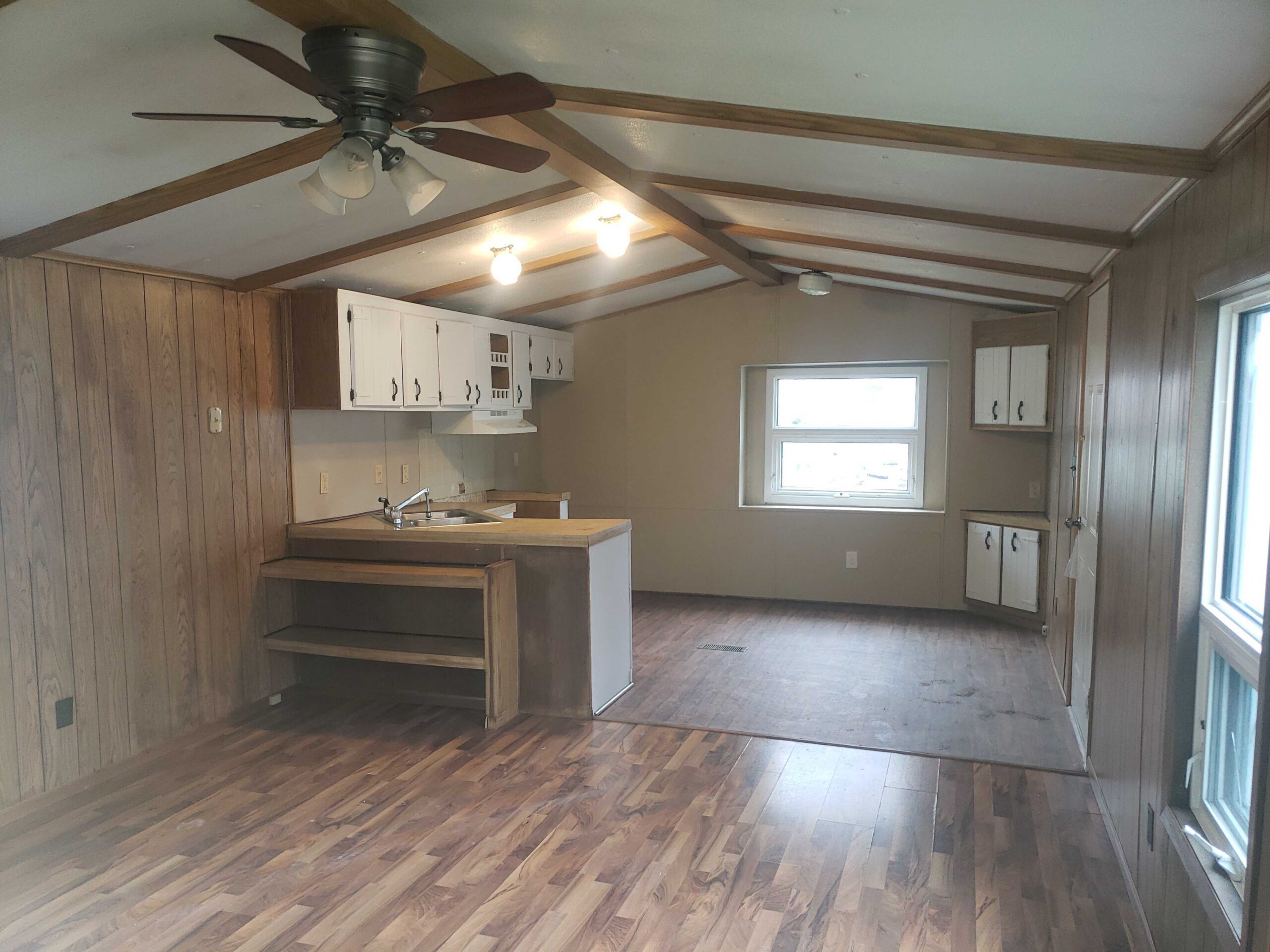 2-bedroom, 1-bathroom home for sale or rent-to-own in Carman Terrace Mobile Home Park with bright living spaces and a woody-like interior.