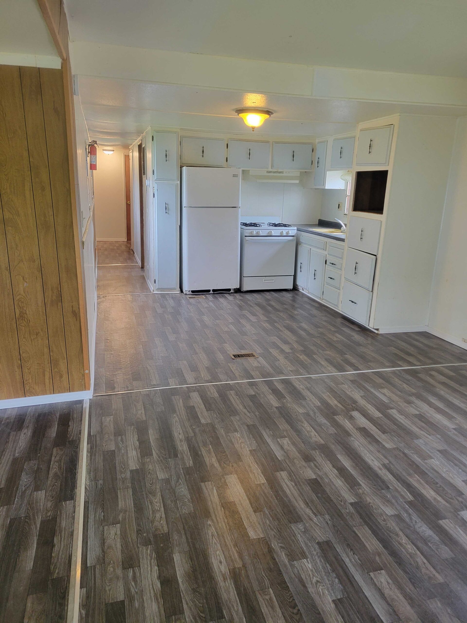 2-bedroom, 1-bathroom home for sale or rent-to-own in Saginaw Mobile Home Park with bright living spaces, a woody-like interior, and a convenient kitchen.